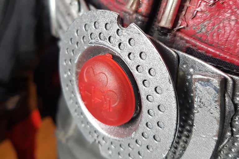 Detailaufnahme eines Metallgehäuses mit rotem Knopf