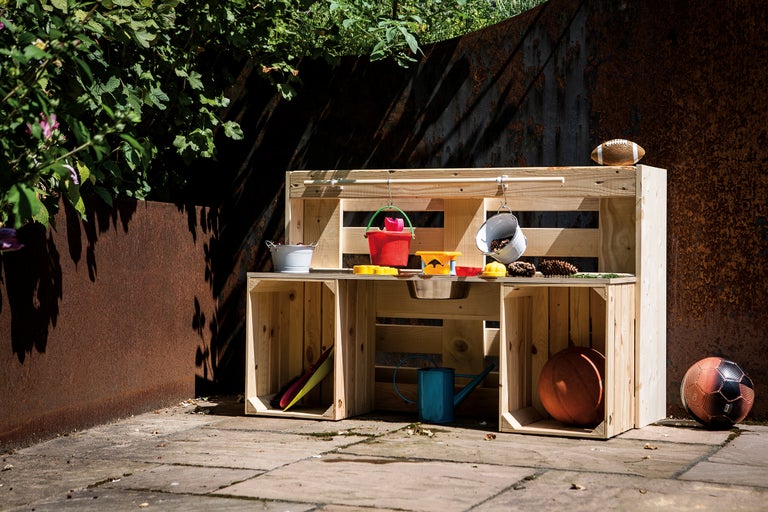 Cuisine de jeu en bois avec jouets dans le jardin
