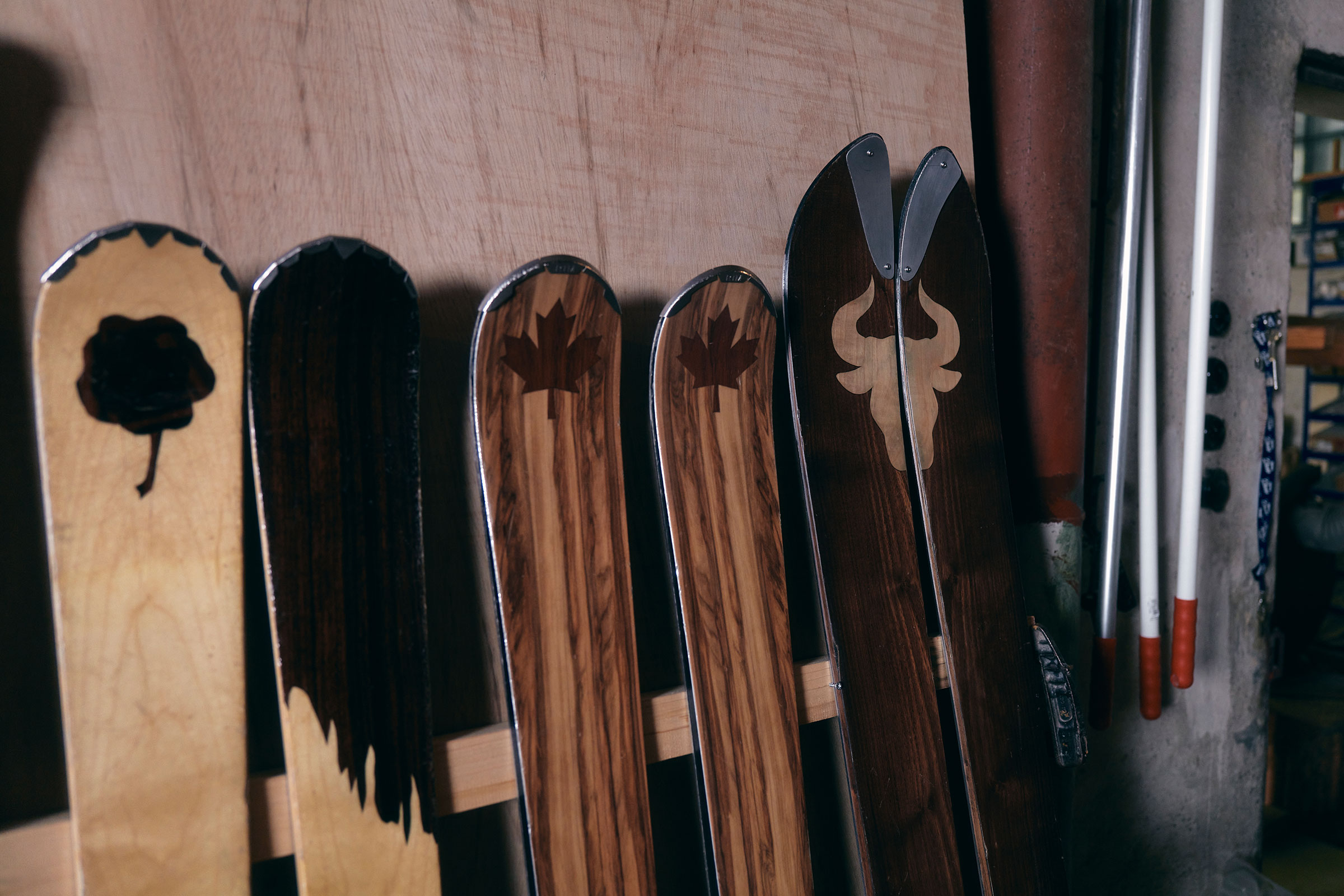 Mehrere Holzskier mit verschiedenen Mustern lehnen an einer Wand.