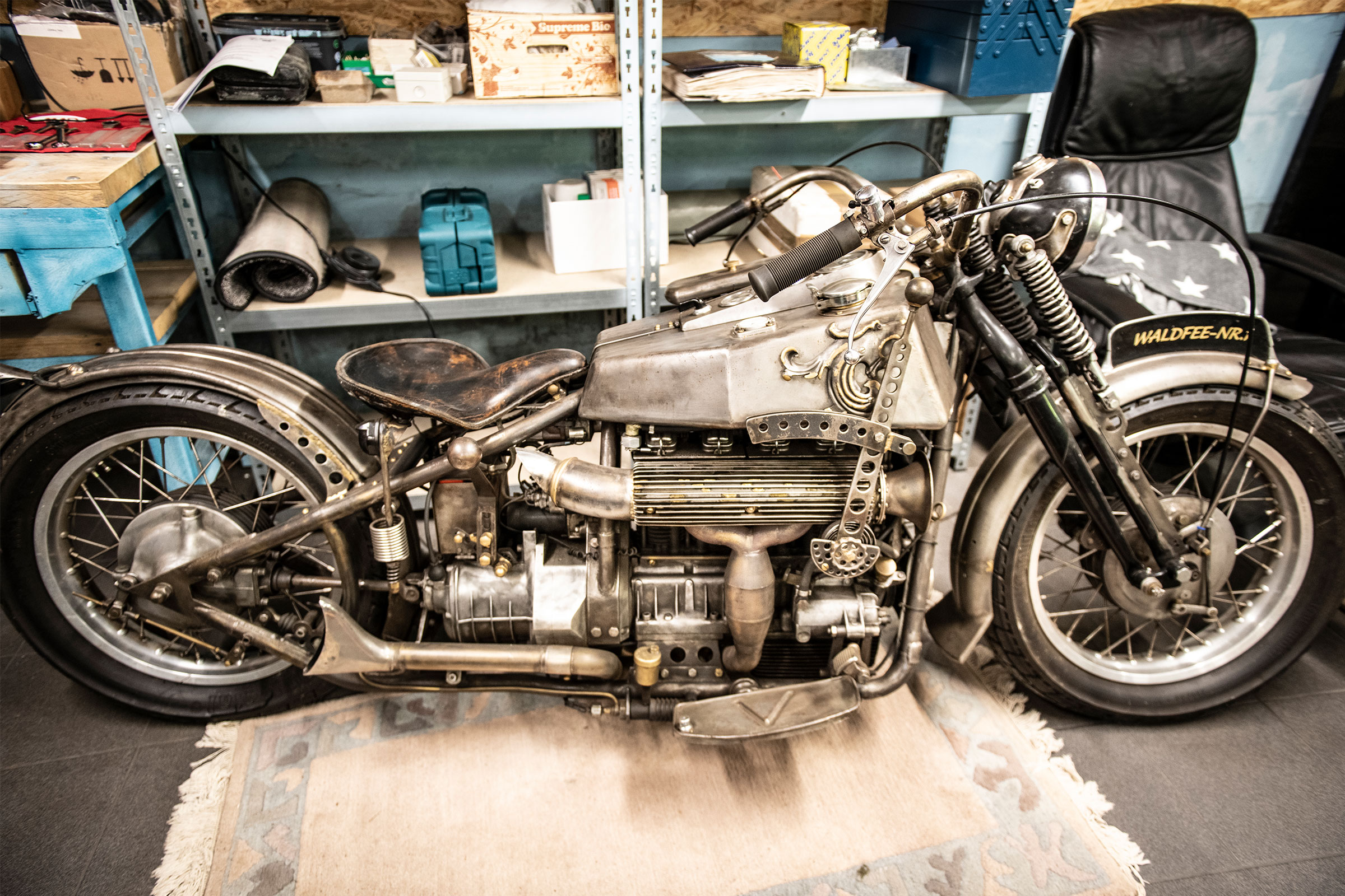 Silbernes Motorrad in einer Werkstatt vor einem Regal