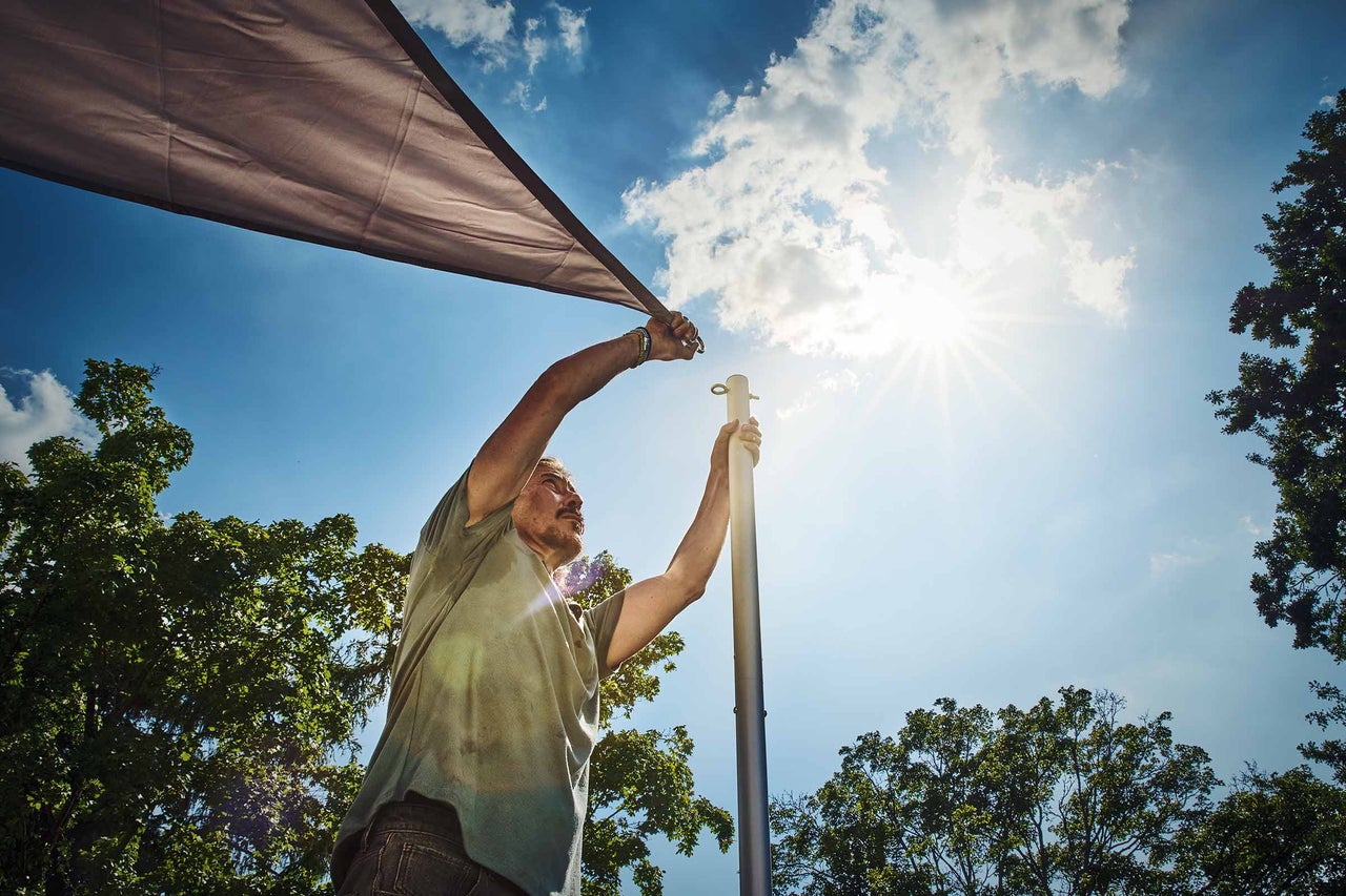 Femme fixant un écran d'intimité avec des crochets sur un balcon