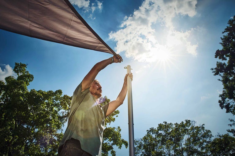 Femme fixant un écran d'intimité avec des crochets sur un balcon