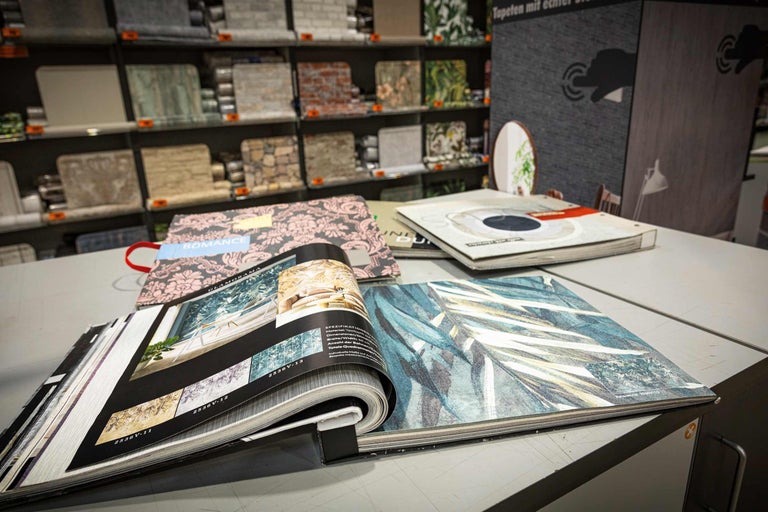 Tapetenmusterbücher mit verschiedenen Designs auf einem Tisch im Hornbach Markt.