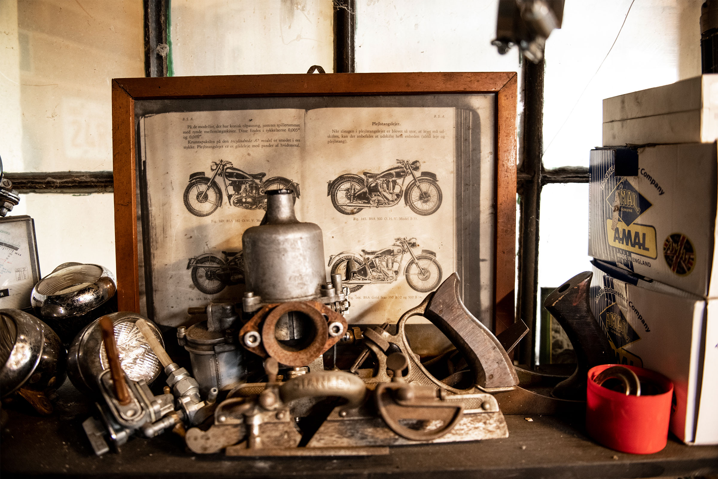 Vintage Werkstattszene mit Werkzeugen, Motorradteilen und einem Buch mit Motorradzeichnungen