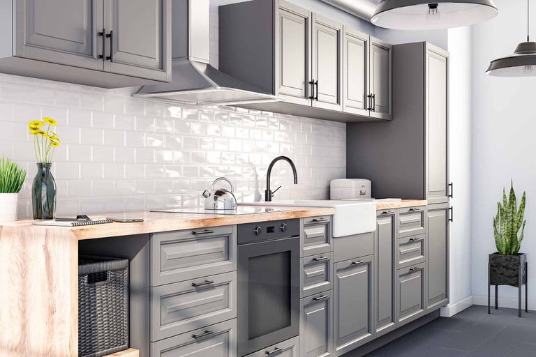 Cuisine moderne avec armoires grises, plan de travail en bois et carrelage blanc