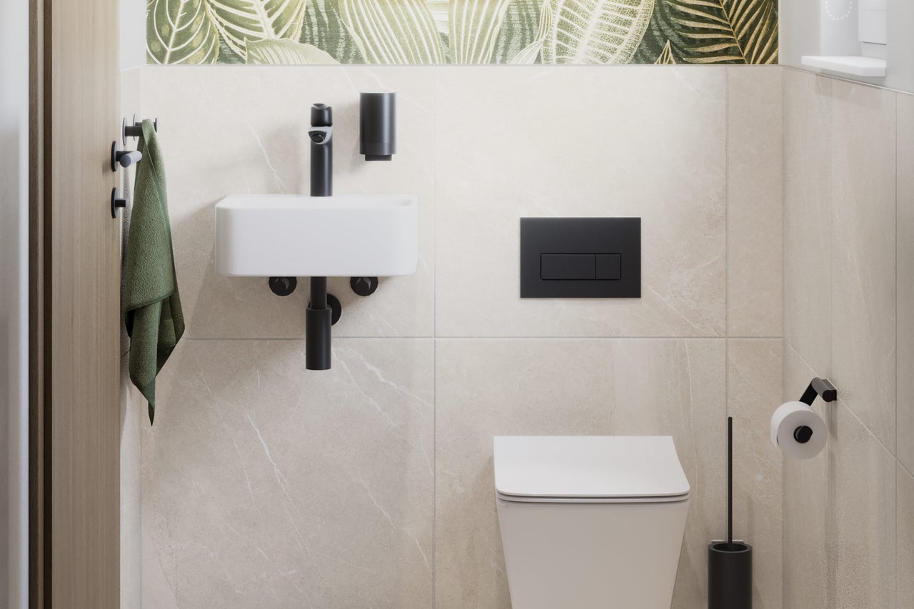 Toilettes invités modernes avec WC suspendu blanc, petit lave-mains, robinetterie noire et carrelage mural beige aspect marbre.
