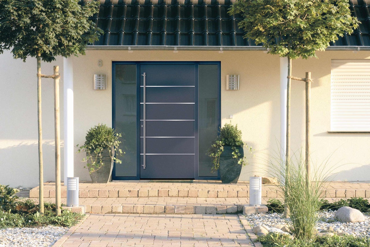Zone d'entrée d'une maison avec porte d'entrée, éclairage et plantes