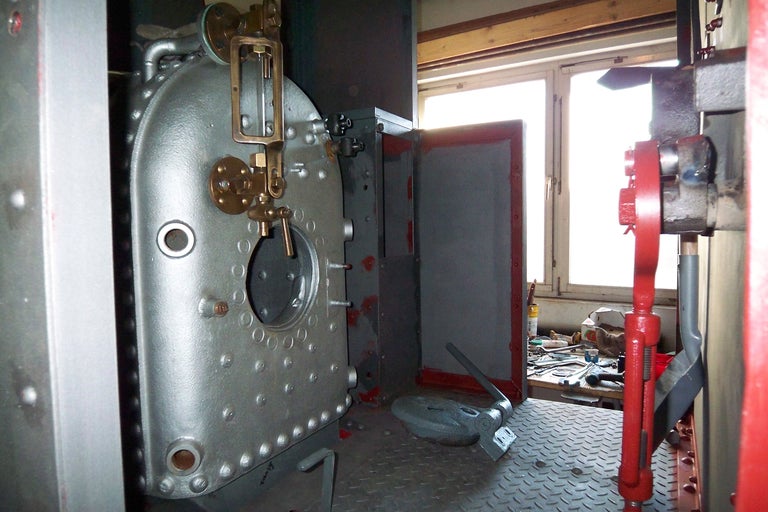 Innenansicht eines Kesselraums mit Kessel und Werkzeugen.