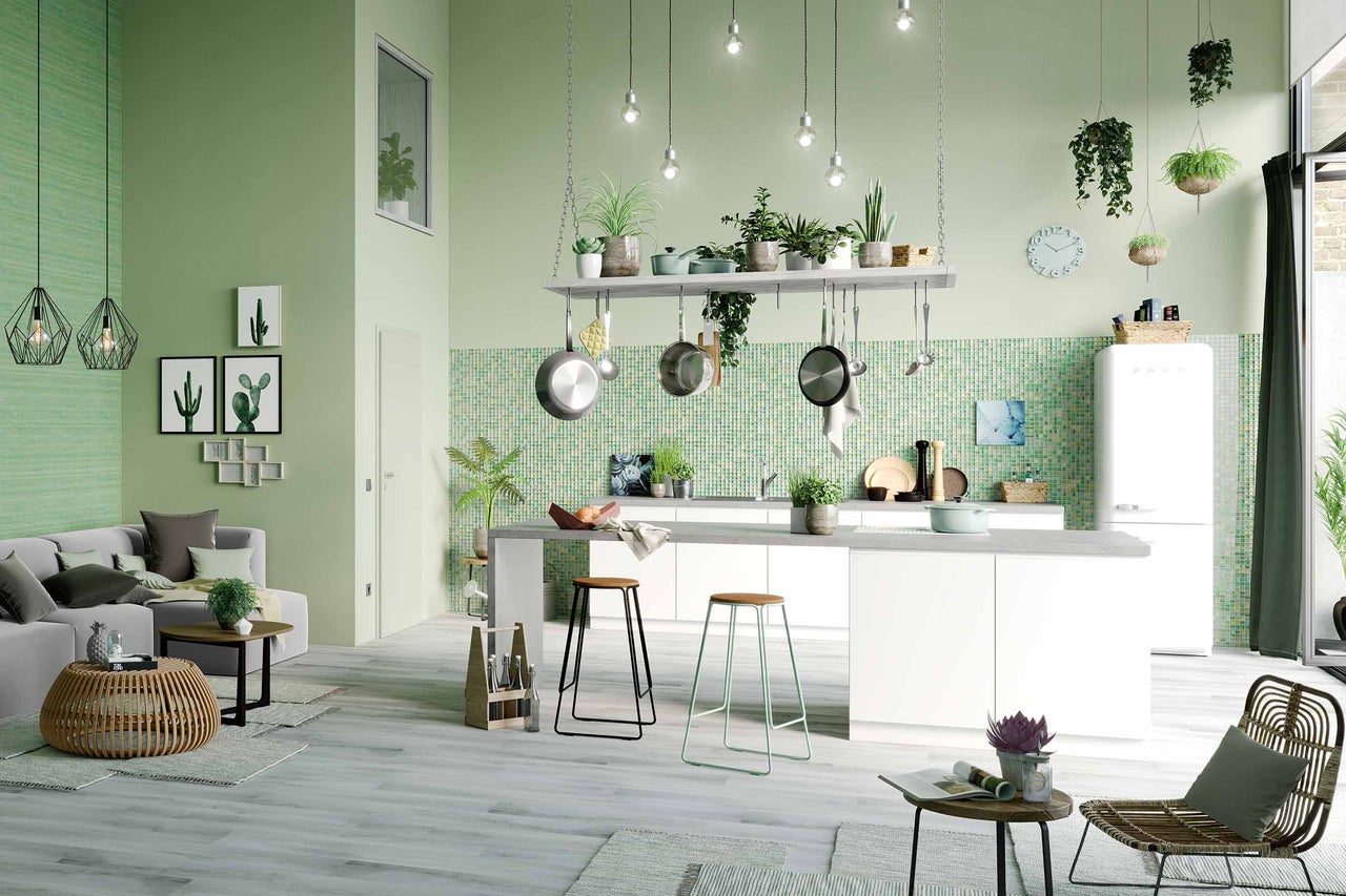 Cuisine d'habitation ouverte et lumineuse avec îlot de cuisine, ustensiles de cuisine et sièges pour une atmosphère accueillante.