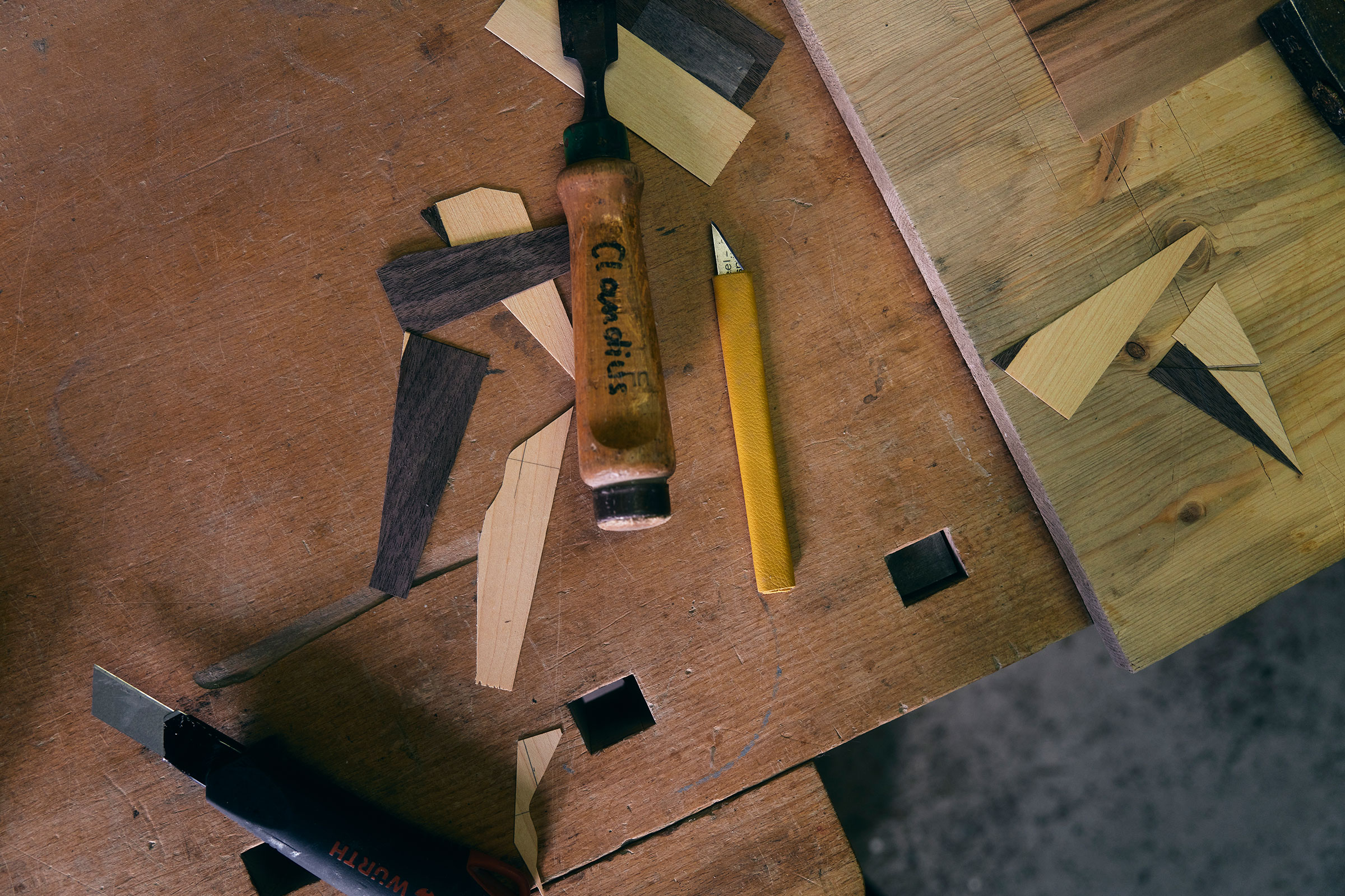 Werkbank mit Stecheisen, Messer und Holzstücken