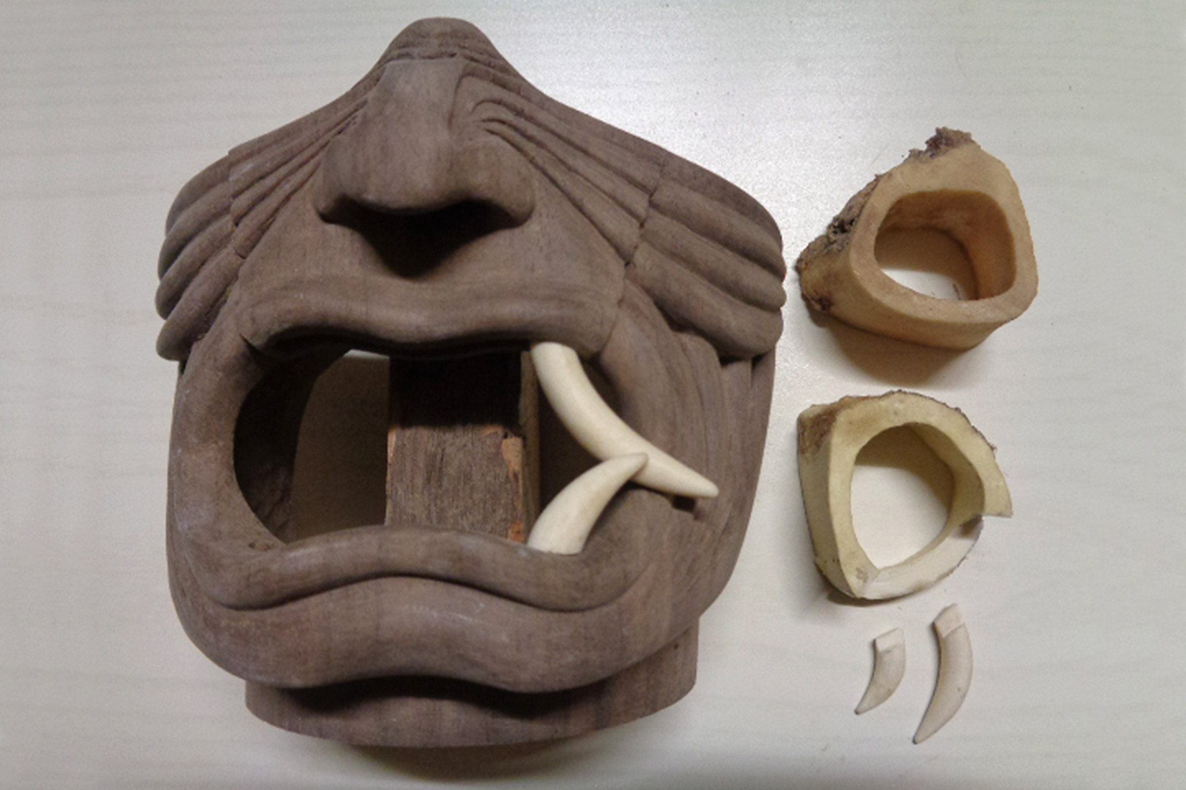 Holzmaske mit geöffnetem Mund und Zähnen