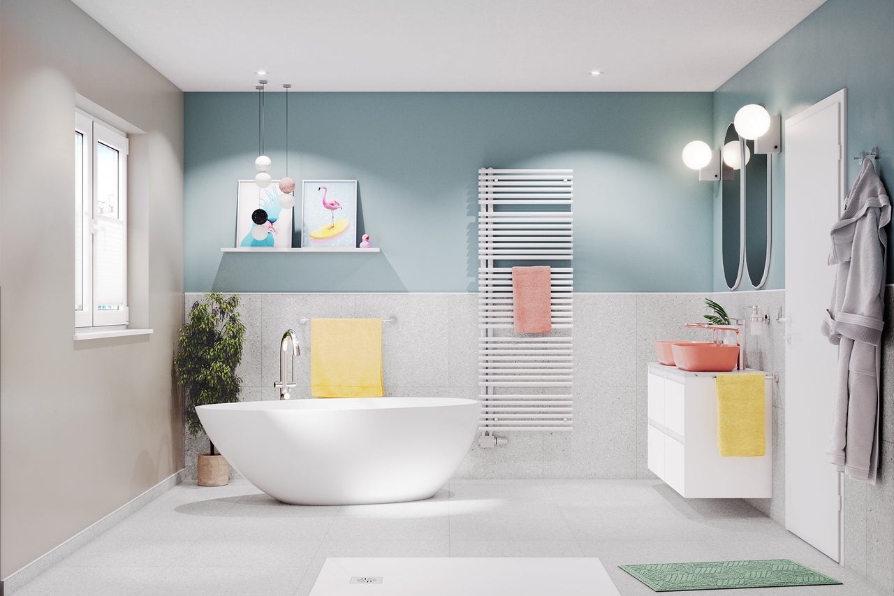 Salle de bain lumineuse avec baignoire, lavabo, sèche-serviettes et décoration