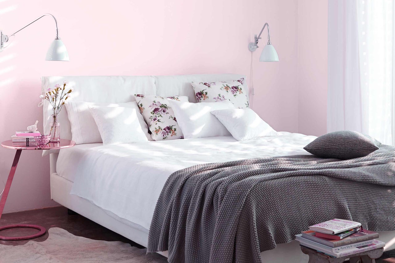 Chambre à coucher accueillante avec lit, oreillers, couverture et table de chevet