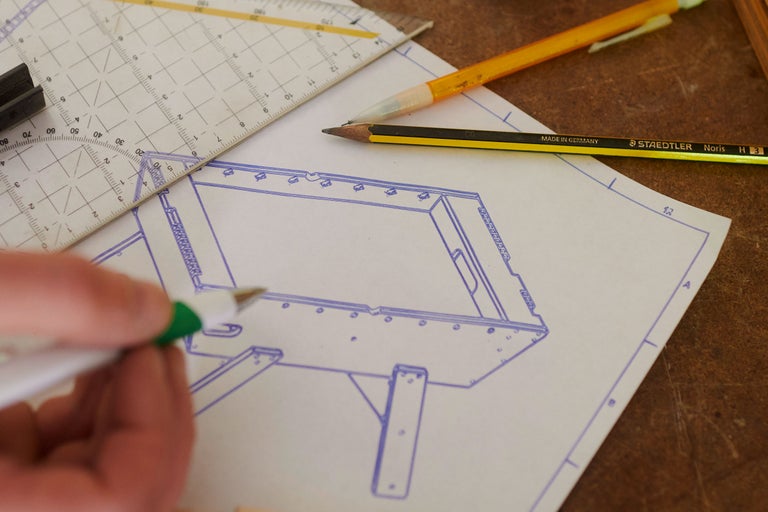 Un plan de construction avec crayon, triangle et couteau à découper