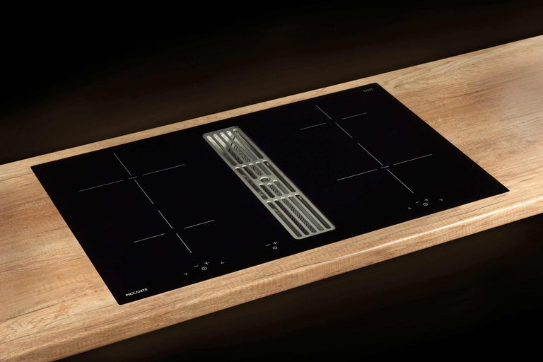 Table de cuisson à induction noire avec hotte intégrée sur un plan de travail