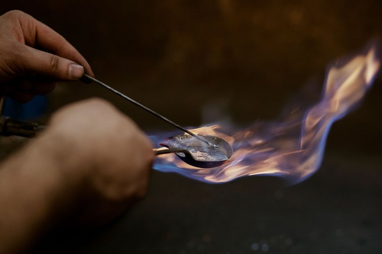 Main soudant du métal avec une flamme