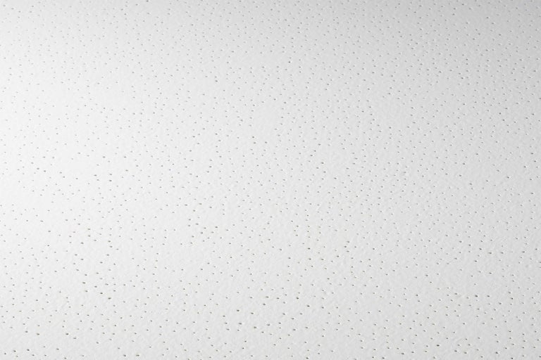 Vue détaillée d'une plaque de plafond avec une fine perforation