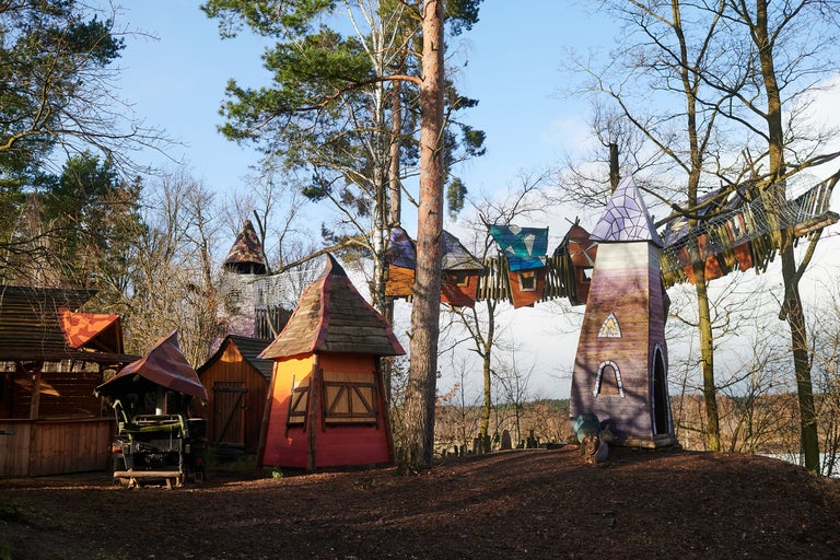 Spielplatz mit fantasievollen Holzhäusern und Baumwipfelpfad
