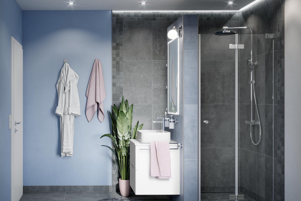Salle de bains lumineuse avec douche, lavabo, miroir et serviettes
