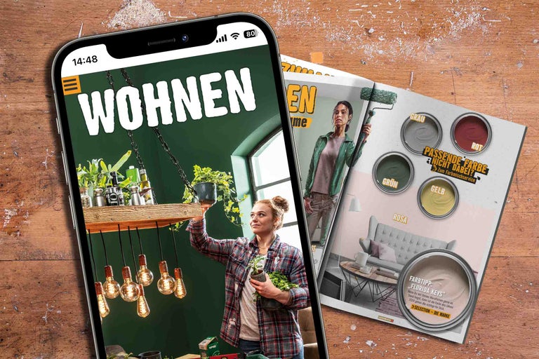 Smartphone affichant le magazine Hornbach Habitat et le flyer du service de mélange de couleurs Hornbach sur une table en bois