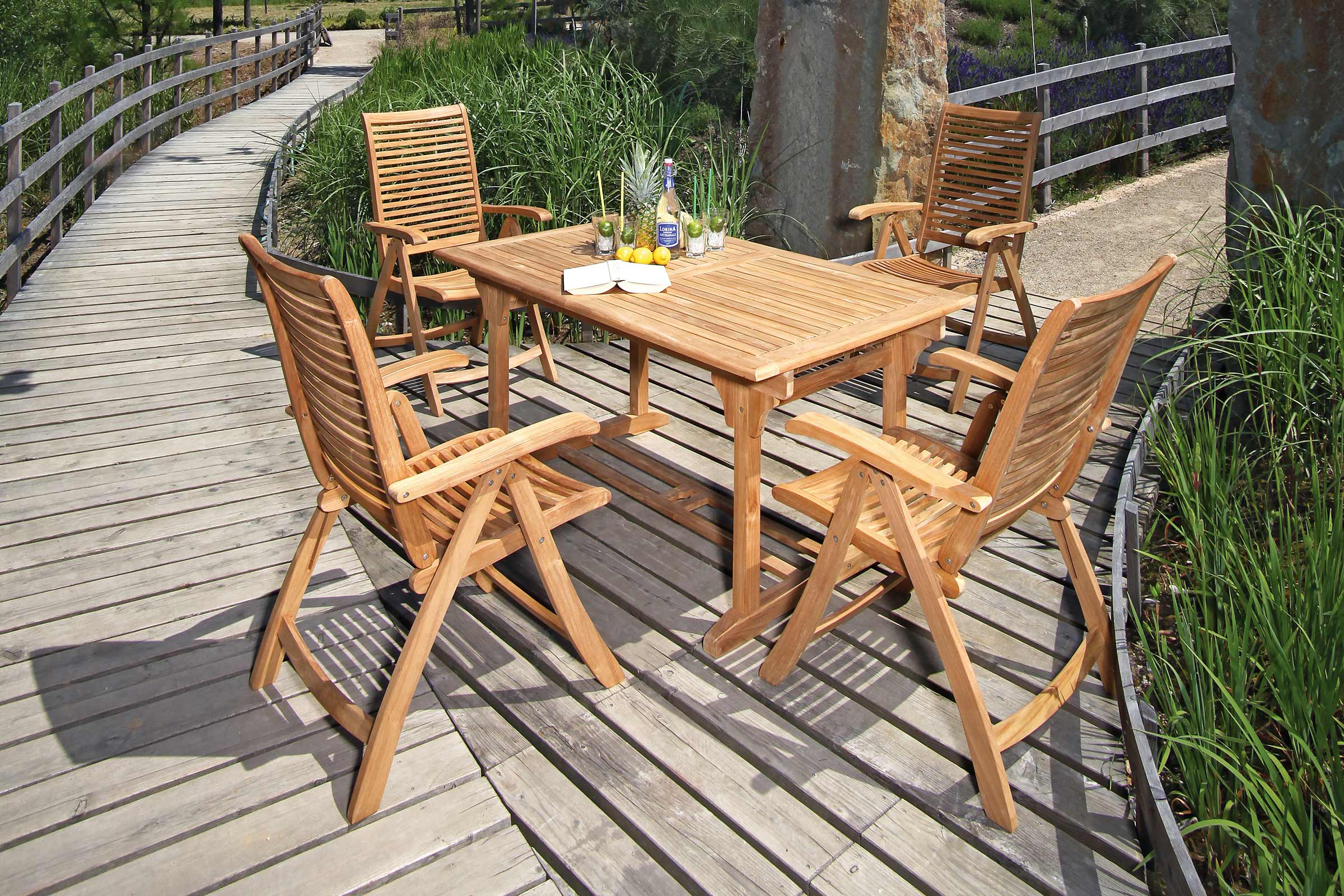 Gartenszene mit Teakholztisch und vier Stühlen auf Holzterrasse