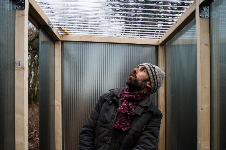 Mann betrachtet Stegplattenkonstruktion im Garten.