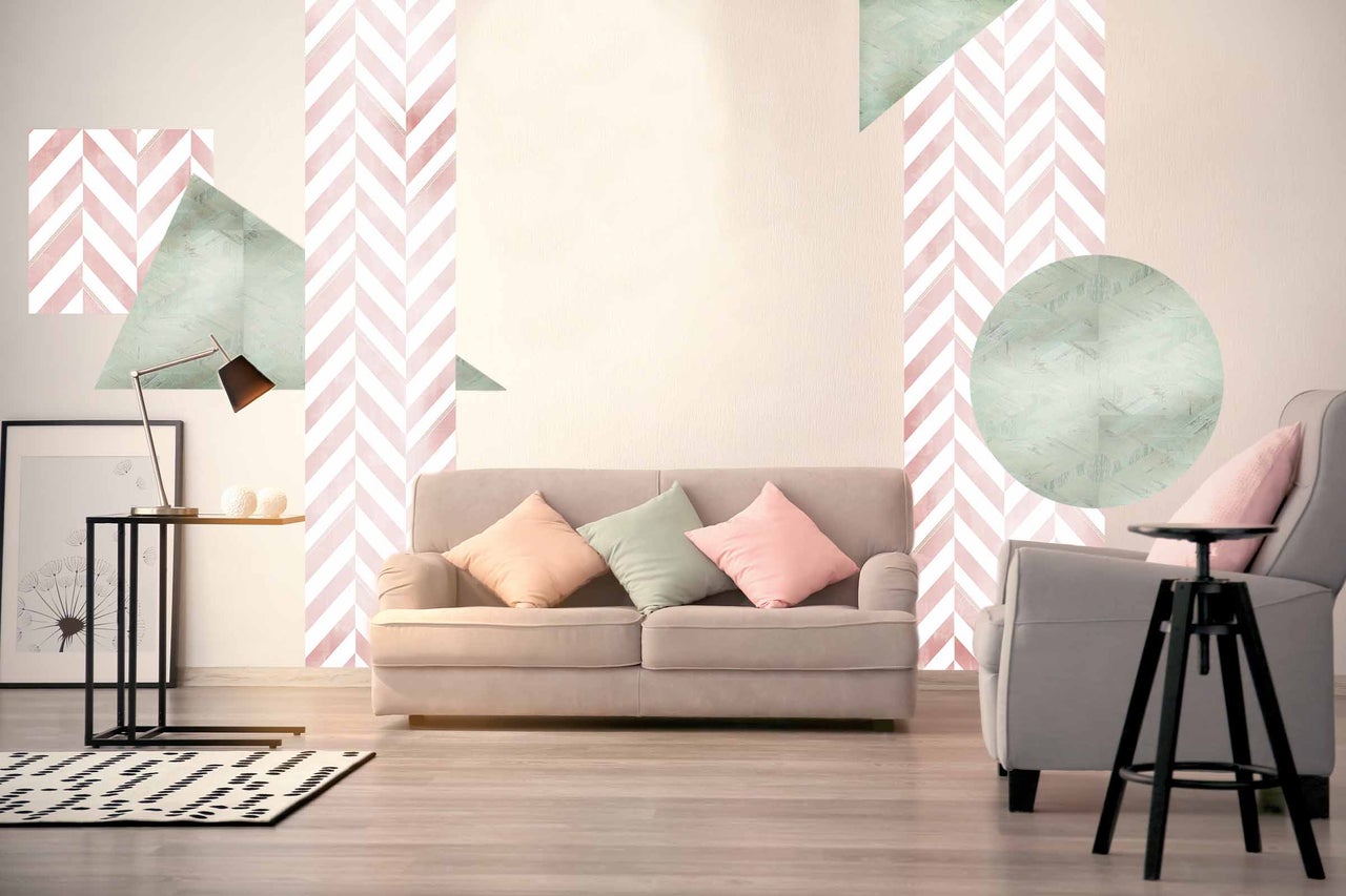 Wohnzimmer mit Sofa, Sessel, Beistelltisch, Lampe und gemusterter Tapete