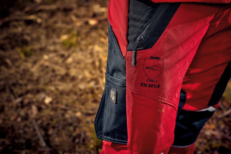 Gros plan d'un pantalon forestier avec fermeture éclair et marquage selon la norme EN 381-5, classe 1