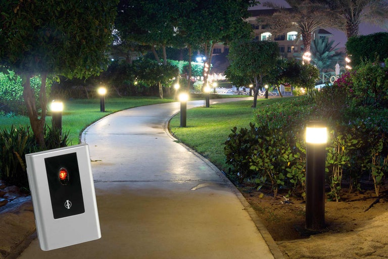 Parklandschaft bei Nacht mit Gehwegen und Beleuchtung sowie einem silberfarbenen Gerät