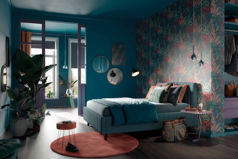 Schlafzimmer mit Bett, Nachttisch, Teppich und floraler Tapete