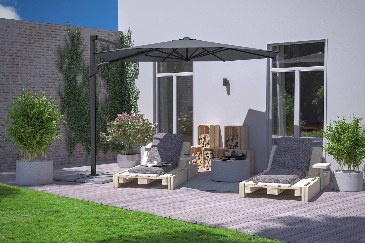 Espace de jardin avec deux chaises longues en bois sous un parasol offrant de l’ombre.