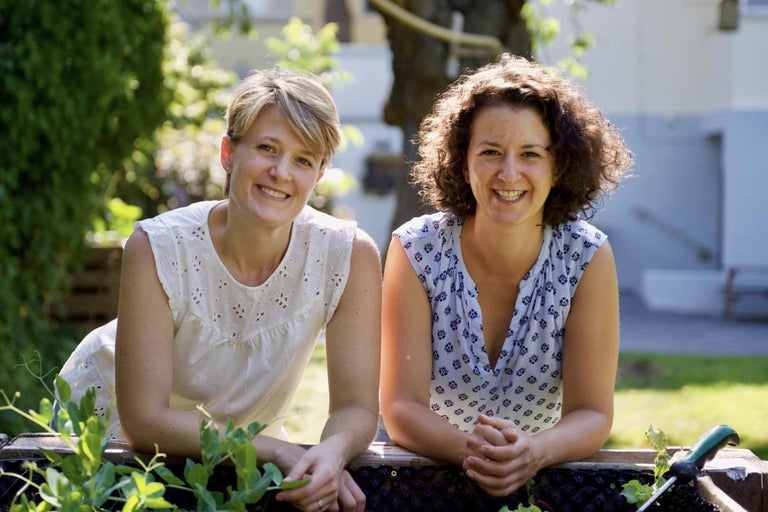 Zwei Frauen an einem Hochbeet im Garten.