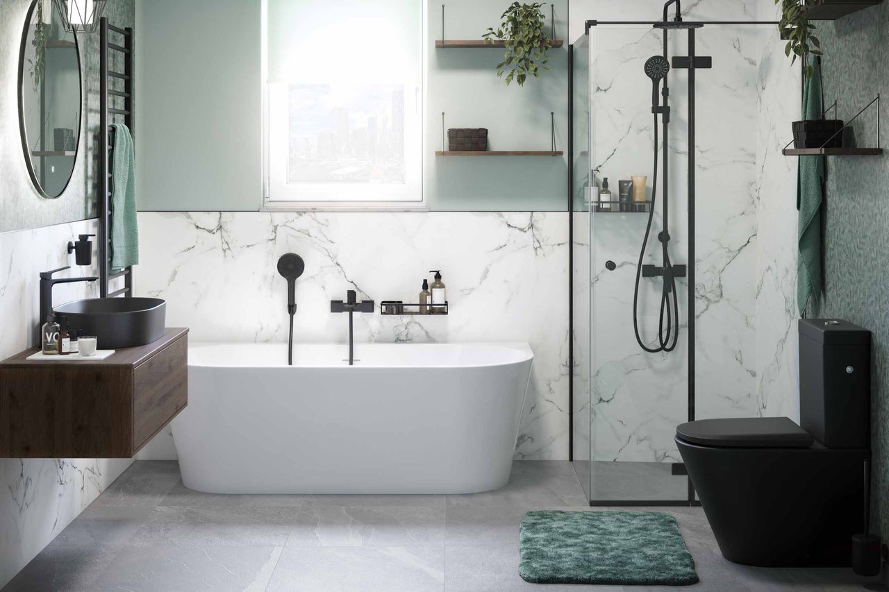 Salle de bain moderne avec baignoire, douche, lavabo et toilettes dans un design lumineux.
