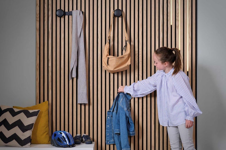 Hall d'entrée avec mur en lambris, patères, veste, écharpe et sac