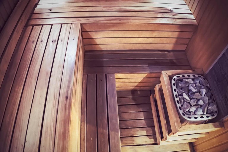 Vue intérieure d'un sauna avec revêtement en bois et pierres de sauna