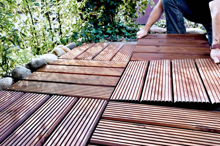 Pose de dalles de terrasse brunes dans le jardin