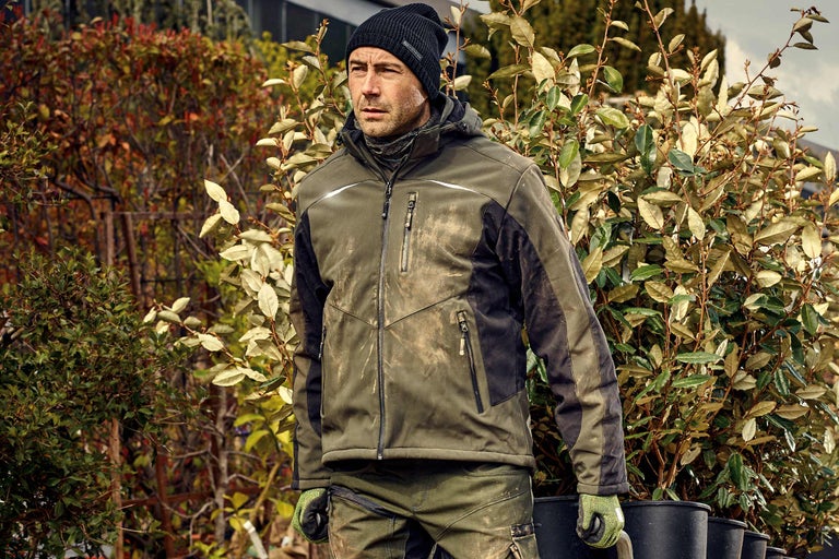 Homme en vêtements de travail avec des plantes à l'extérieur.