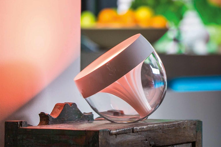 Dekorative Tischleuchte mit transparentem Glasschirm auf einem Holztisch