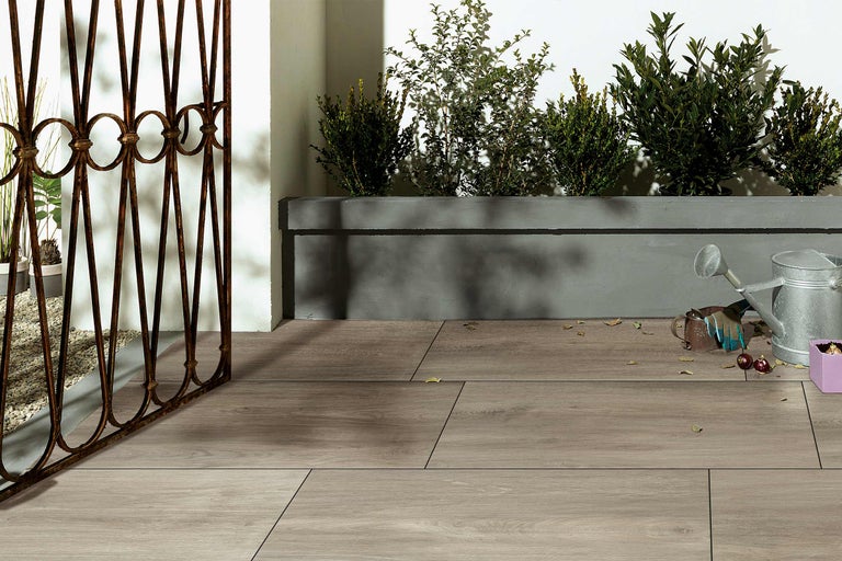 Terrasse avec planches en bois, jardinière et clôture de jardin