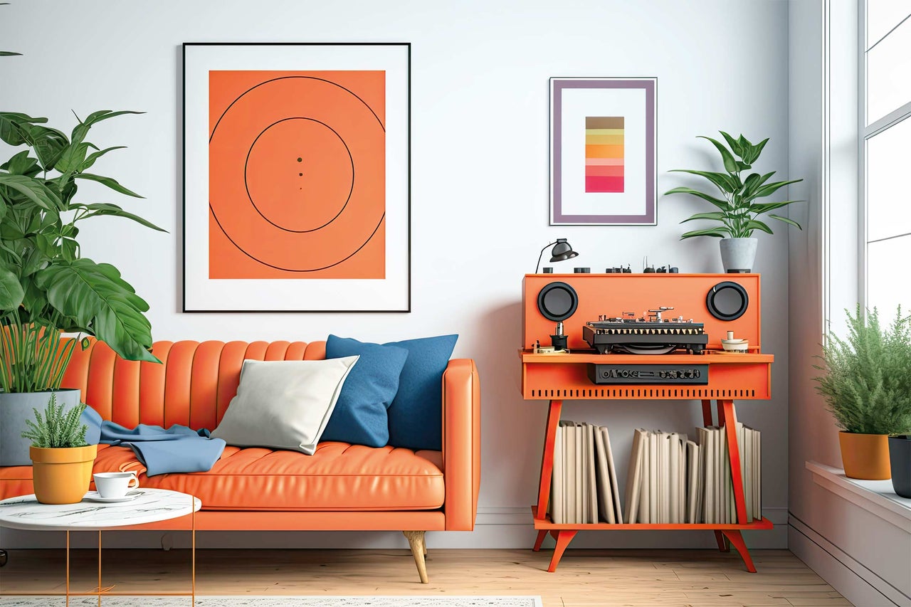 Salon avec canapé orange, tourne-disque, plantes et œuvres d'art au mur.