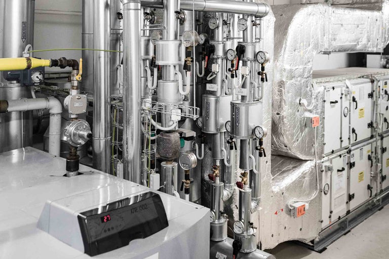 Komplexes Heizungs- und Lüftungssystem mit Rohren, Messgeräten und Steuerungseinheiten.