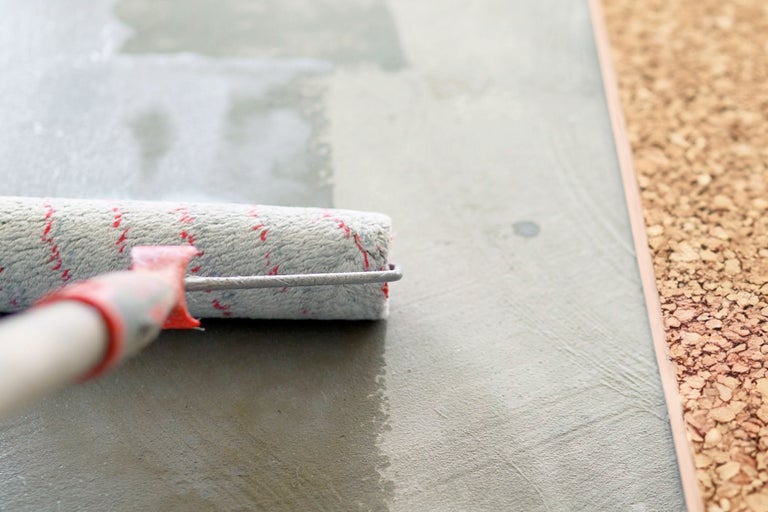 Rouleau à peinture appliquant de la peinture sur une surface à côté du liège