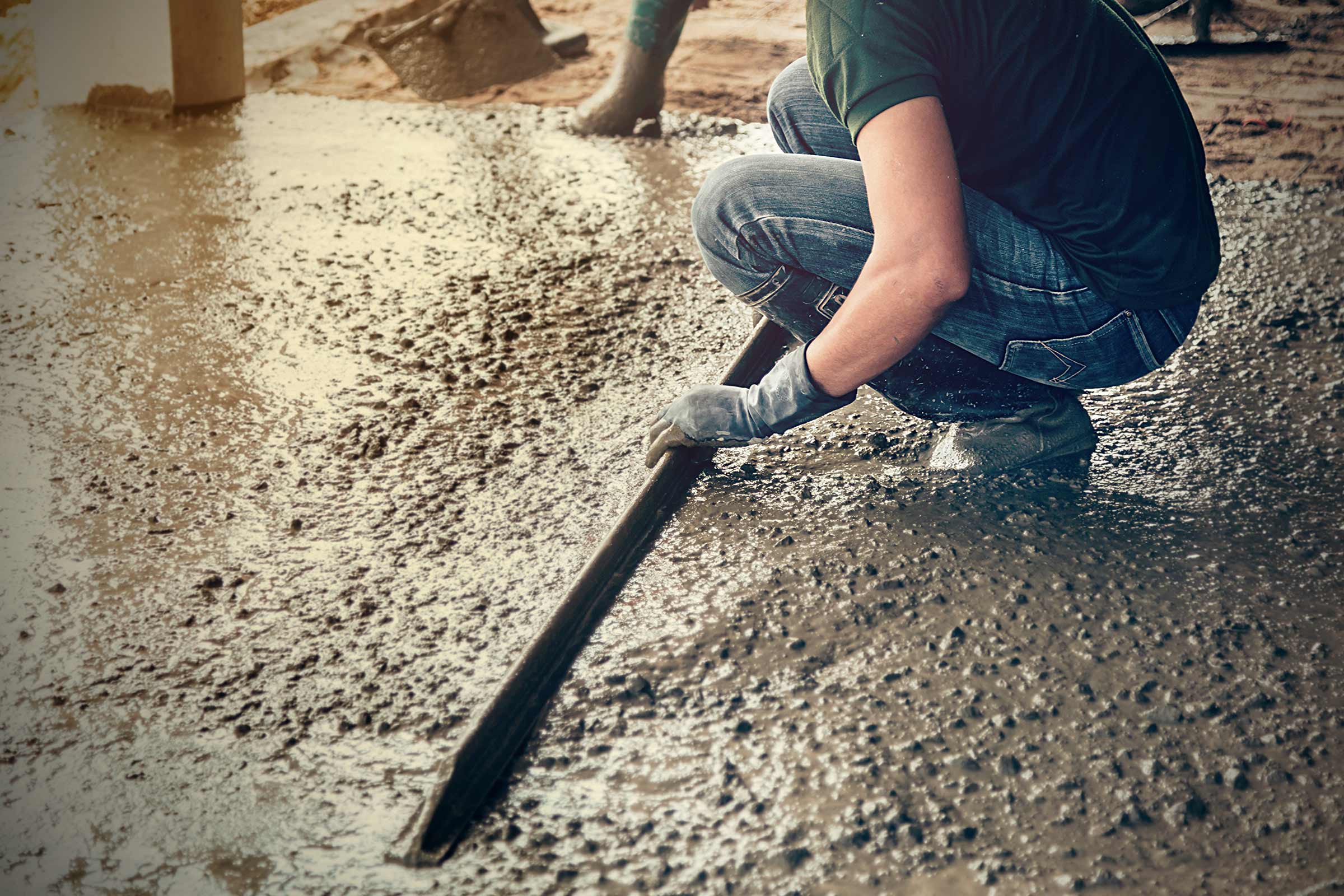 Person glättet Beton mit einem Werkzeug