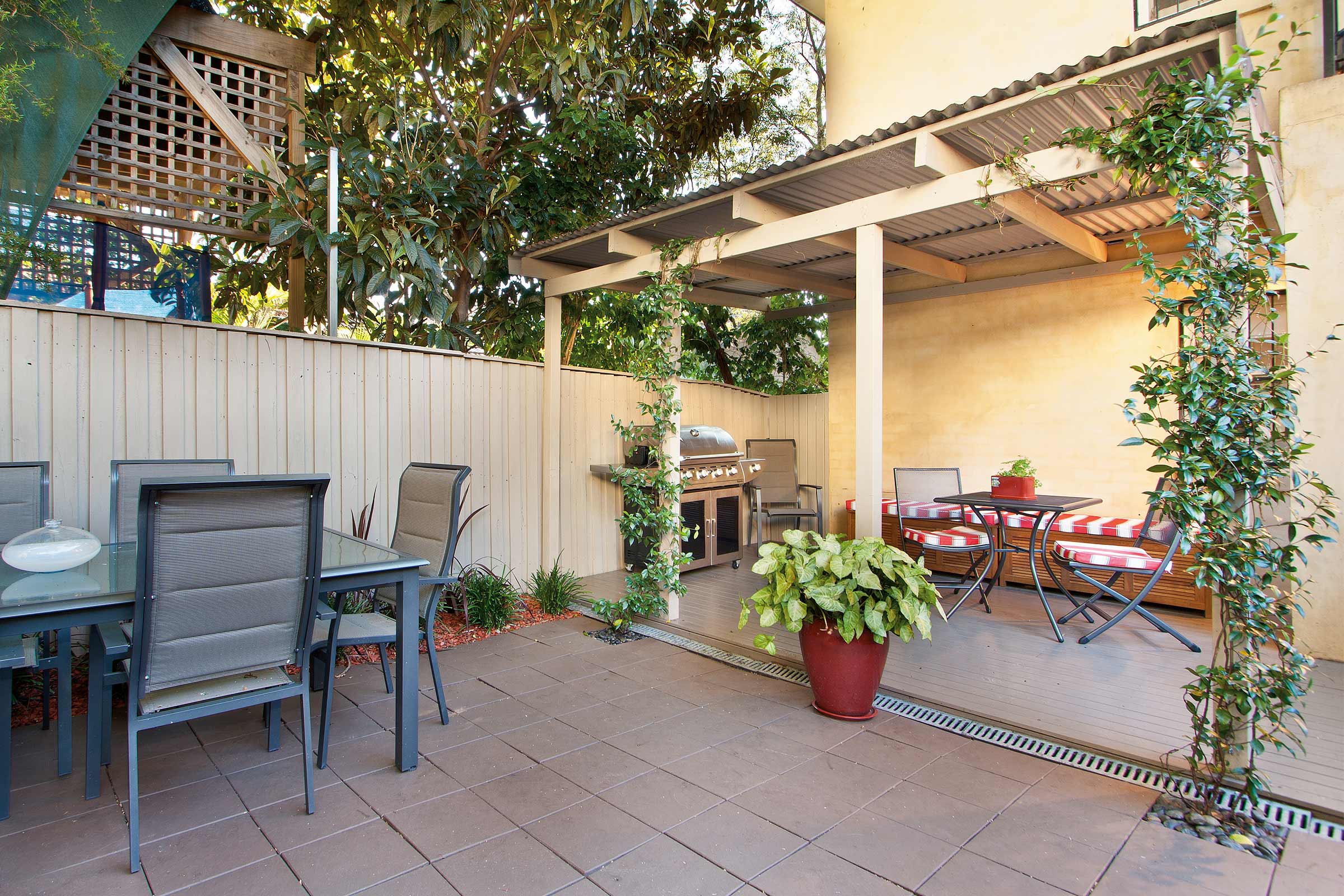 Terrasse mit Gartentisch, Stühlen, Grill und Pflanzen