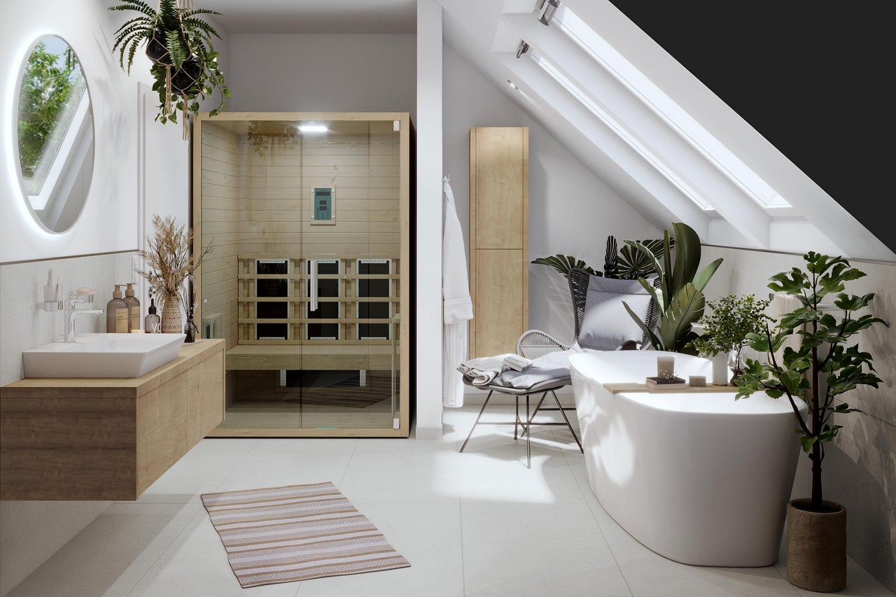 Salle de bains lumineuse avec sauna, lavabo, baignoire et fenêtres de toit