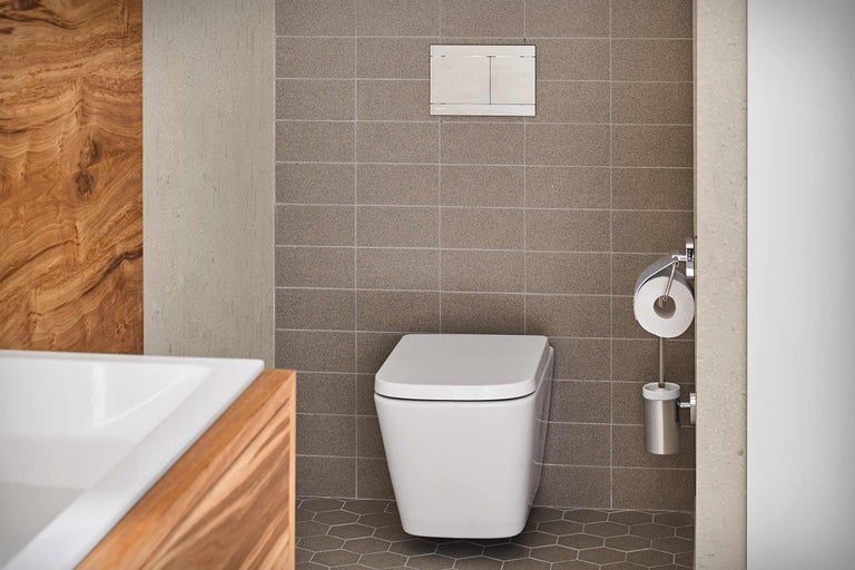 Salle de bains moderne avec WC suspendu, plaque de commande et porte-papier toilette