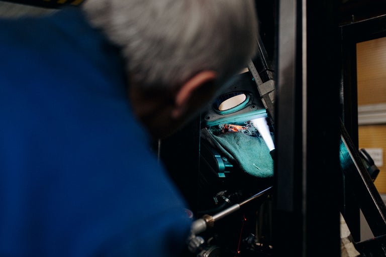 Mechaniker arbeitet an einer Maschine mit Werkzeugen und einer Decke