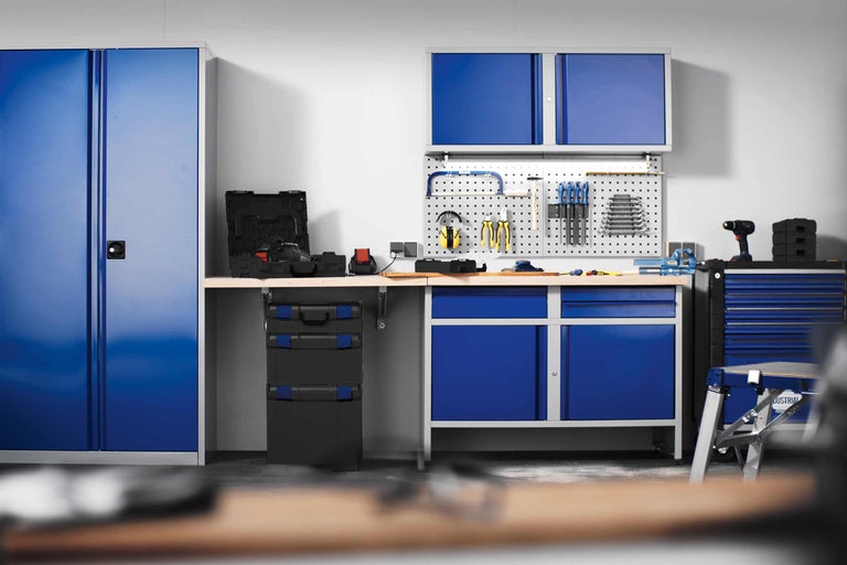 Atelier avec établi, armoire à outils et panneau mural pour un environnement de travail organisé