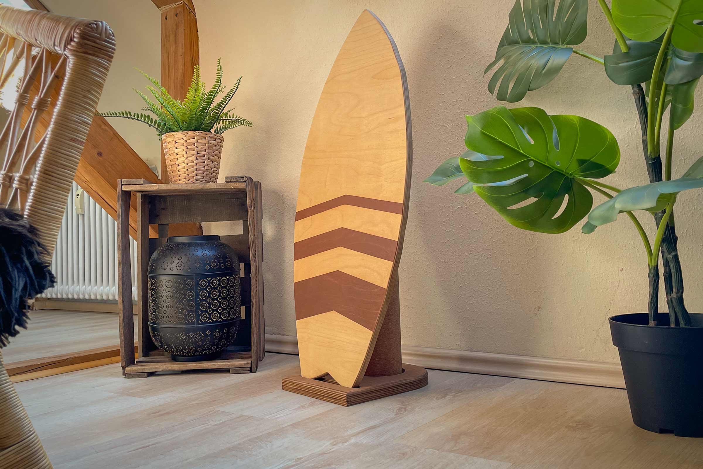 Dekoratives Holz Surfbrett mit Pfeilmuster und Pflanzen