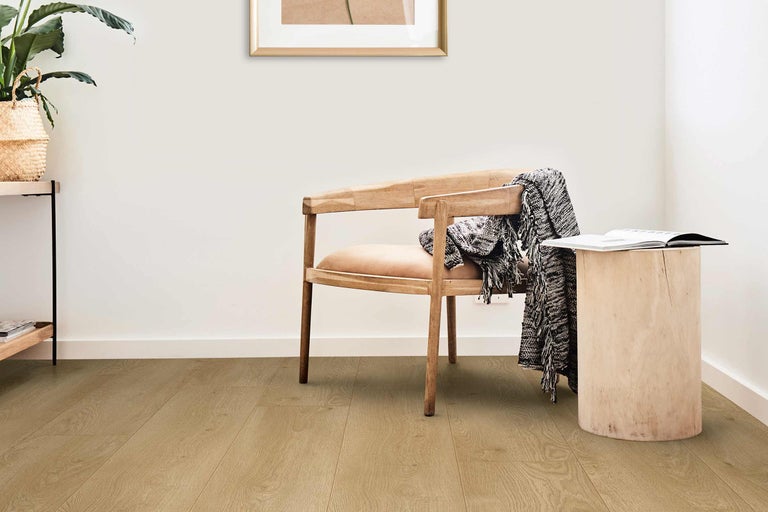 Pièce lumineuse avec parquet, chaise en bois et table d'appoint en tronc d'arbre